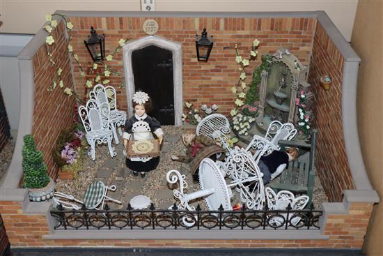 A group of three dolls house models of shops with figures and accessories and an unfinished dolls house